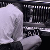Kenteken: A 841; Ford Consul, vervangen van de kentekenplaat vlak bij de grens, 1954, foto: still uit de film "5 snipperdagen" coll. GrA (2209-AV18819)