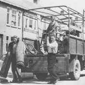 Kenteken: A 27429; Groningen, Vinkenstraat, verhuizing familie Muller, Lammert Muller (l.), Anne Muller (r.), Vos (b.l.) en Lolke Muller, 1947 (1785-25437)