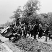 Kenteken: A 13660; Chevrolet (A-11176) in de sloot naast boerderij Krassum en de takelwagen van de Ennam. Op de achtergrond de kerk van Garnwerd. foto: E.H. Kremer - van Wensveen