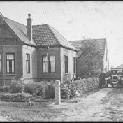 Kenteken: A 14300; Pieter Timmer en Maria Timmer-Brust naast de Chevrolet bij hun huis, met hun dochters in de tuin en op het balkon, 1928 (2437-5826)