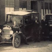 Kenteken: A 1297; Staande (met snor) Eppo Beereboom bij de beide Ford wagens, met links op spatbord en rechts zijn beide zoons, Mennonietenkerkstraat, Uithuizen, ca. 1926, uitsnede foto E. Beereboom