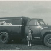 Kenteken: A 9731; Peta Hopma naast de Studebaker, Hogestraat, Loppersum, ca. 1950, foto: <a href='https://beeldbank.hvloppersum.nl/items/show/2739' target='_blank'>Historische vereniging Loppersum</a>