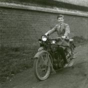 Kenteken: A 17574; Mensingeweer, jongen poseert op de Indian motorfiets naast de schuur van een boerderij aan de Schouwerzijlsterweg (2138-1842)