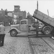 Kenteken: A 25177; Eendrachtskade Zuidzijde, Ford vrachtwagen nr. 23 gemeentereiniging stort 'ingezameld' koper in schip ca. 1942 (1785-23707)