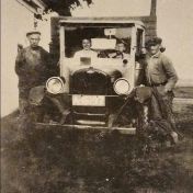 Kenteken: A 16197; Chevrolet, met staand links Willem Poort, in de auto Tietje W. Poort en Harmannus Poort, rechts Anne Bosklopper, foto: <a href='https://oudwesterkwartiernoordenveld.nl/2024/05/15/de-eerste-vrachtauto-van-de-firma-poort-te-doezum/' target='_blank'>OudWesterkwartierNoordenveld</a>