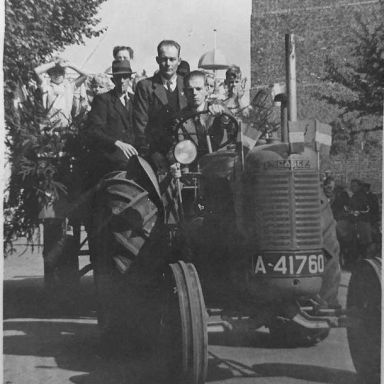 Kenteken: A 41760; Sam Kleefsman op de Case tractor, achter hem staat Hindrik Huzeling, op de achtergrond de Juffertoren van Schildwolde, foto: K. J. Mollema