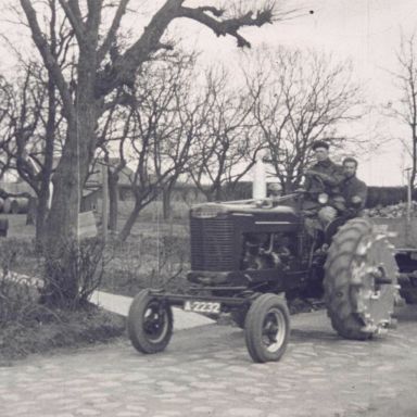 Kenteken: A 2232; Farmall MD tractor met volgeladen aanhangwagens bij de boerderij van Tilma, foto: still uit de film "Boerderij, ploegen e.d. onbekend", 1950-1954, coll. GrA (2209-1075)
