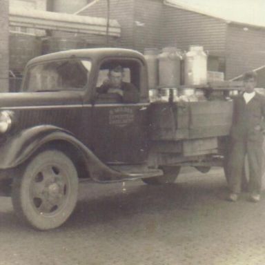 Kenteken: A 20368; Bruin Mulder in zijn Ford vrachtwagen geladen met melkbussen, foto: J. Knollema-Mulder