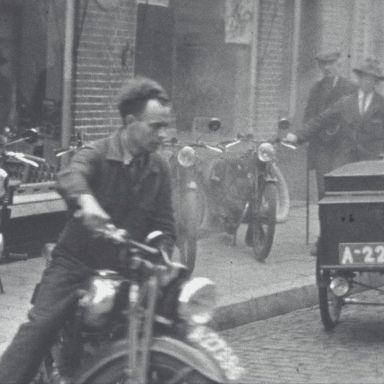 Kenteken: A 22798; Motorbakfiets, Winschoten, Engelsestraat, foto: still uit de film "Winschoten, Koopstad van het Oldambt en Westerwolde", 1937-1939 coll. GrA (2209-20766)