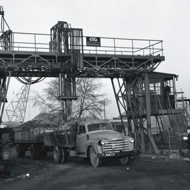 Kenteken: A 6643; Hoogkerk, Suikerfabriek, mechanische grijper haalt een monster uit de met suikerbieten beladen Chevrolet vrachtwagen, 1955 (2248-6433); Fotograaf: Fotobedrijf Piet Boonstra