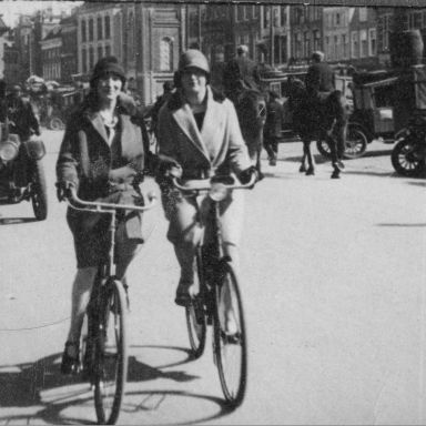 Kenteken: A 2696; H.M. Furda (1915) en J.J.A. Furda (1910) op de fiets in Groningen. Op de achtergrond de Buick met kenteken A-2696, foto W. G. de Jonge