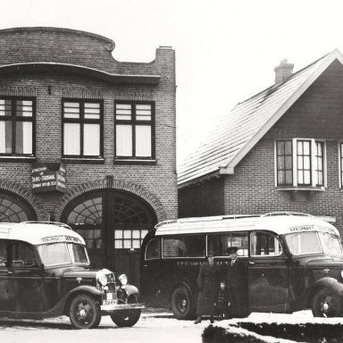 Kenteken: A 4342; Ford V8, remise autobussen firma Bergman, Ter Apel, staande voor de bus chauffeur (en later tijdelijk bedrijfsleider) Fokkema met echtgenote en zoontje Henk, 1935 (1785-14461)