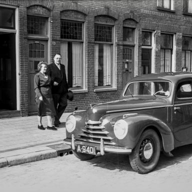 Kenteken: A 9401; Confectiebedrijf Menco, Groningen, Nieuwe Kijk in 't Jatstraat, jubilaris mejuffrouw Lammers wordt naar de Skoda gebracht (2248-27165); Fotograaf: Fotobedrijf Piet Boonstra